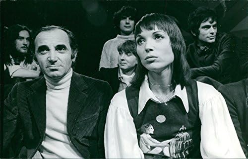 Foto vintage de Elsa Martinelli sentada com um Charles Aznavour.